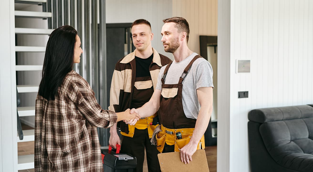 Ügyfél és szerelő kezet fog dokumentumokkal a kézben, a hosszú távú karbantartási együttműködés jelképeként.