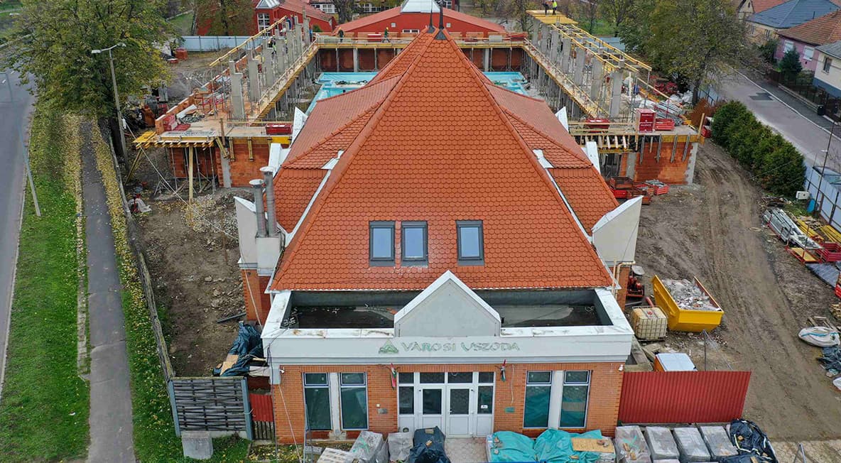 Légifelvétel a városi uszoda meglévő épületéről és a fejlesztés alatt álló bővítésről.