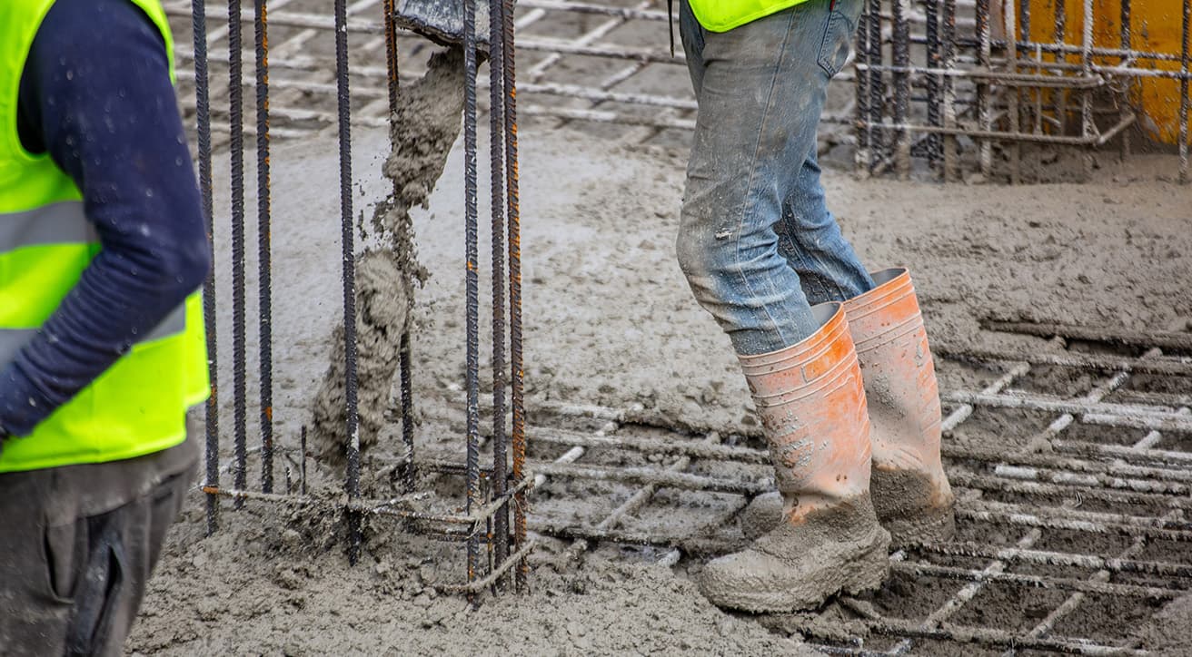 Betonozási munka acél vasalás mellett, az alapozási és szerkezetelőkészítési folyamat közben.