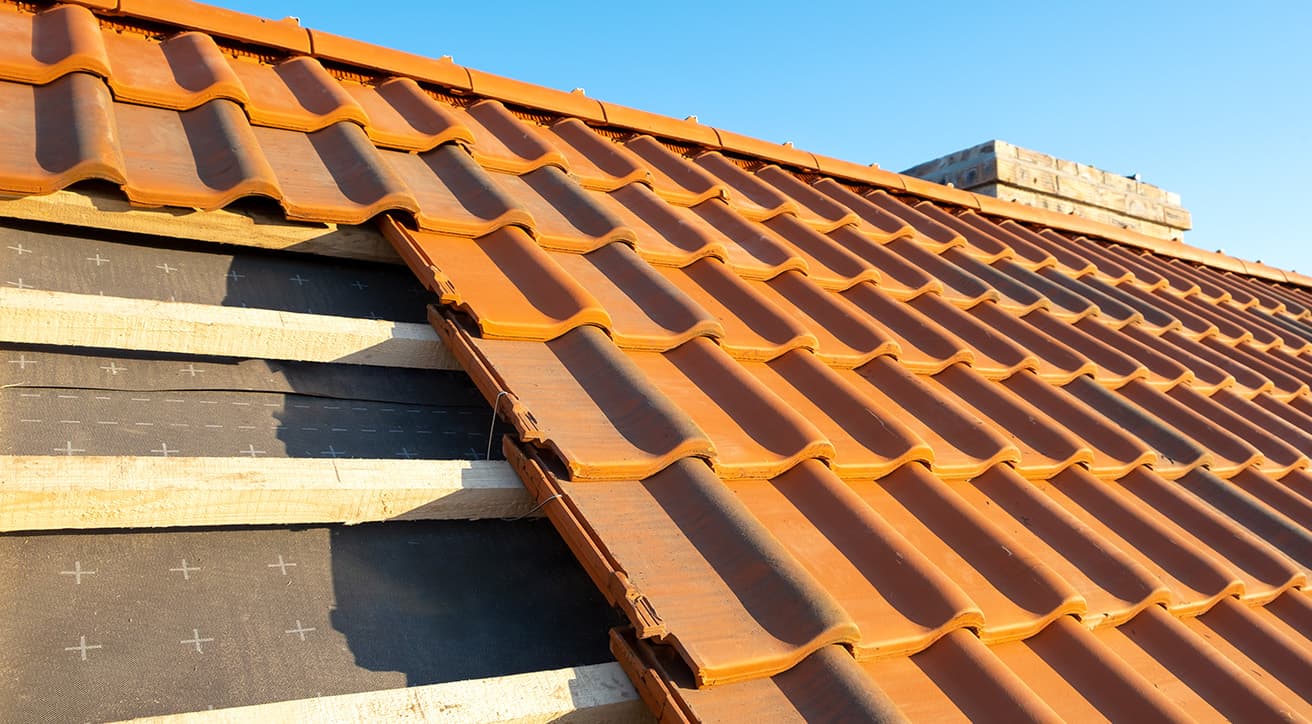 Tetőfelújítás közeli részlete cserépfedéssel, alátéthéjazattal és lécezéssel.