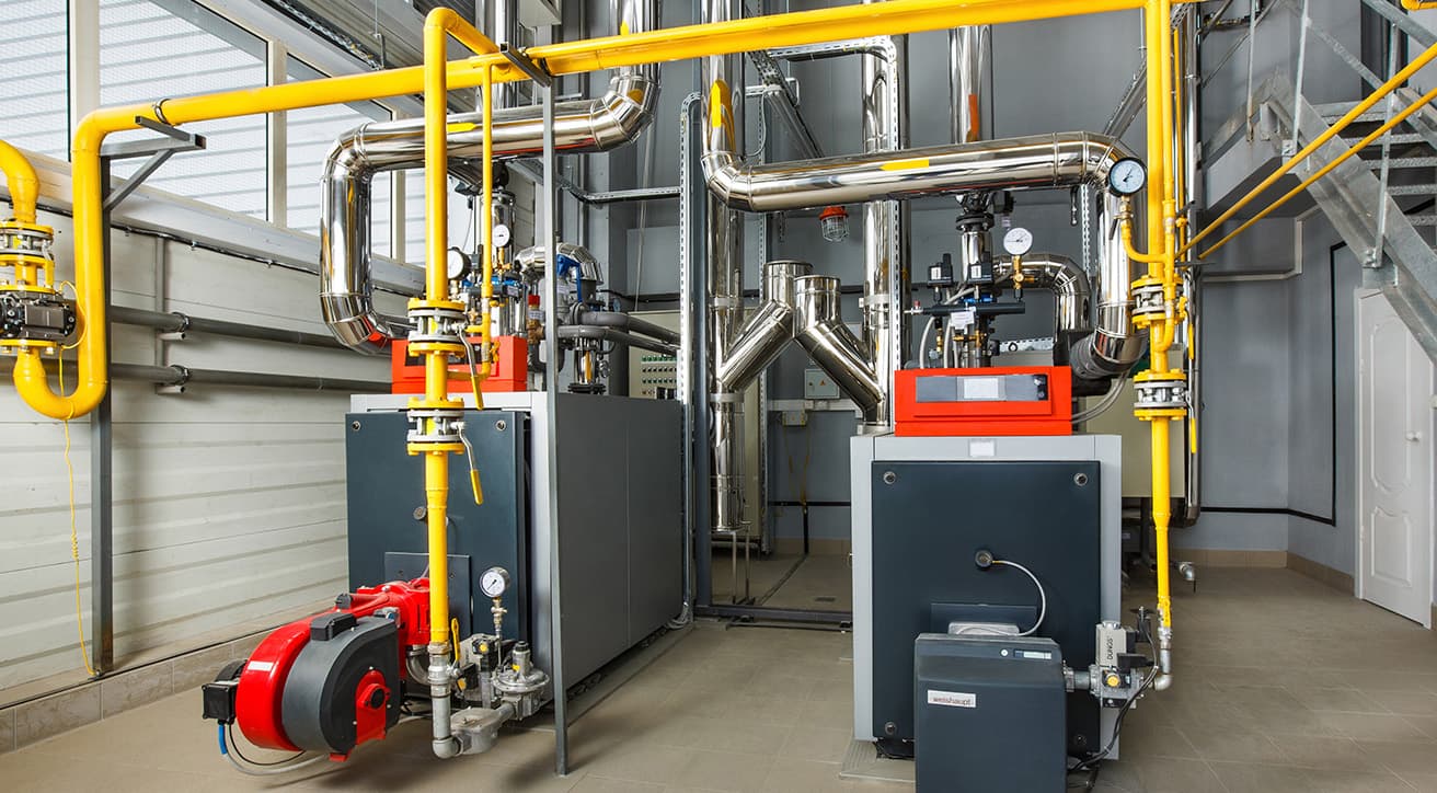 Ipari kazánház belső tere kazánokkal, csőhálózattal és szerelvényekkel, folyamatos üzemeltetésre kialakítva.