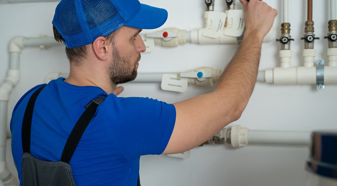 Szerelő vízvezeték- és csőrendszert ellenőriz falra szerelt szelepekkel és csatlakozásokkal.